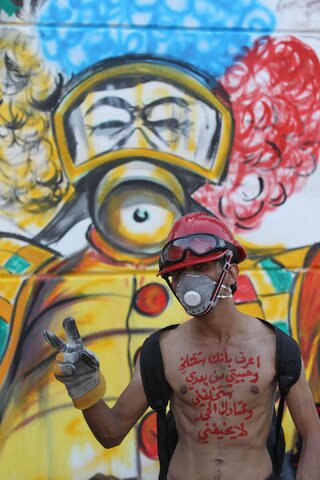 یک مرد معترض که روی سینه‌اش نوشته است: «می‌دانم که مرا خواهید کشت و معشوقم پس از من مرا دوباره به دنیا خواهد آورد و گلوله‌های جنگی شما مرا نمی‌ترساند!»