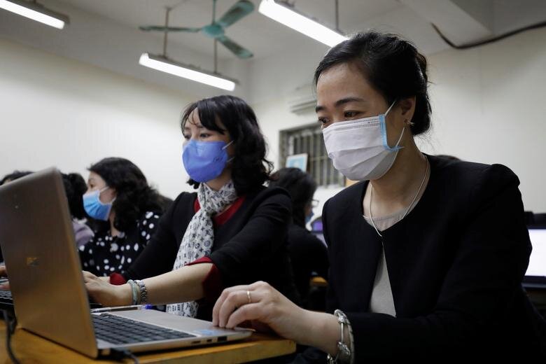 هانوی/ ویتنام. معلمان در حال تدریس آنلاین در حالی که ماسک محافظ دارند