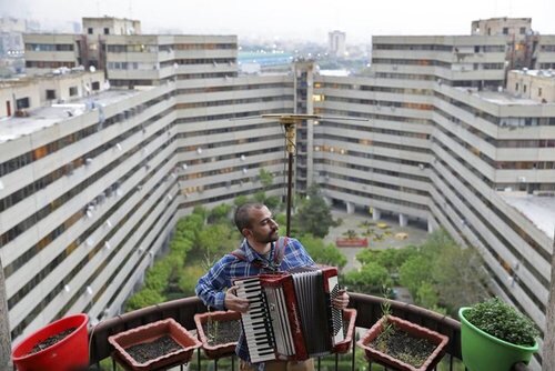 "بهنام عمران"28 ساله در حال نواختن آکاردئون در پشت بام خانه خود در شهرک اکباتان در تهران 