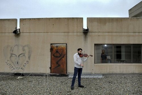 "بهراد سوخاکیان" 37 ساله عضو ارکستر ملی ایران در حال نواختن ویولون در پشت بام منزل در تهران 