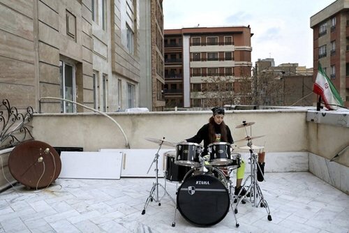 "فرید سرسنگی" 29 ساله در حال نواختن "درام" در پشت بام خانه در تهران 