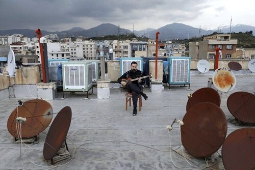 "مدیا فرج نژاد" 38 ساله در حال نواختن تار در پشت بام خانه در تهران 