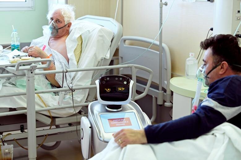 رباتی که به تیم پزشکی برای معالجه بیماران کرونایی در بیمارستانی در ایتالیا کمک می‌کند.