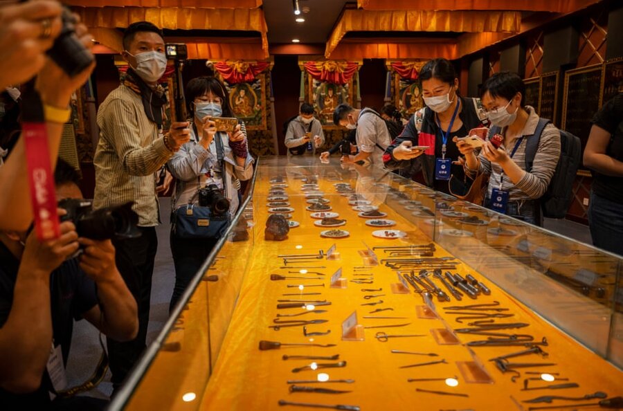 روزنامه نگاران و مسئولان به نمایشگاهی در شرکت پزشکی گانلو تبتی نگاه می کنند .