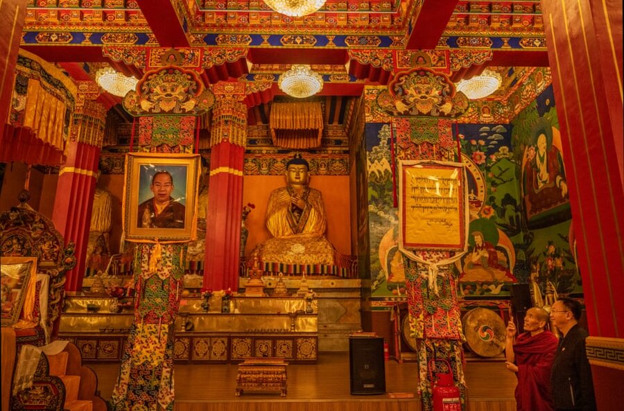 یک راهب بودایی اطراف معبد اصلی در شهرستان قوشوی را به یک مقام رسمی نشان می دهد .