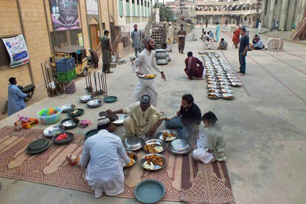 يك خانواده پاكستاني در حال كمك به برگزاري مراسم افطار جمعي هستند.