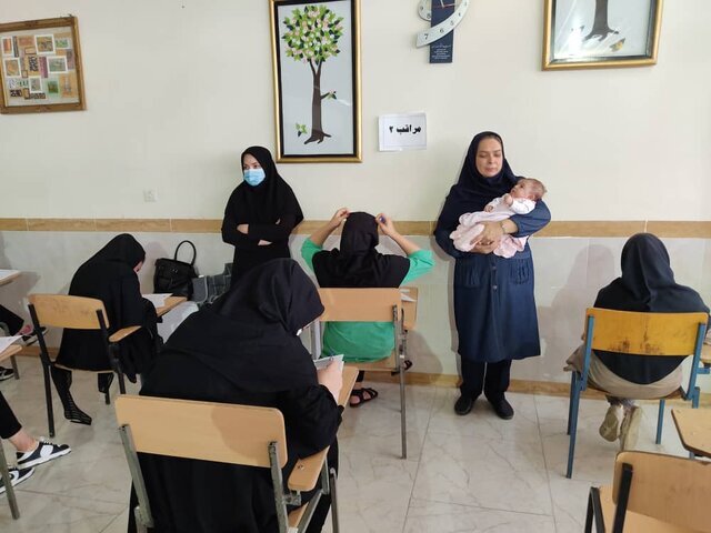 ماجرای عکس عجیب حضور یک نوزاد در آغوش مراقب کنکور | واقعیت تصویری که دردسرساز شد؛ این حوزه امتحانی کجاست؟