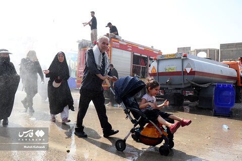 تصاویر آب‌پاشی به زائران برای جلوگیری از گرمازدگی