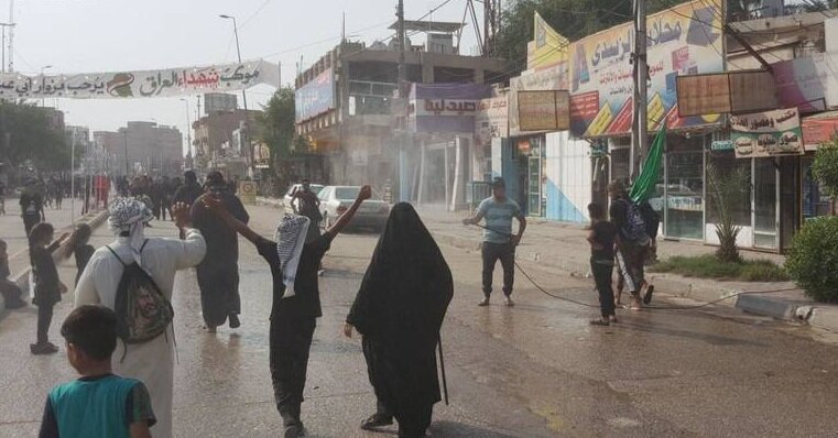 عکس | آب پاشی کوفیان به روی زائران | موکب های « کوفه» خلوت تر است