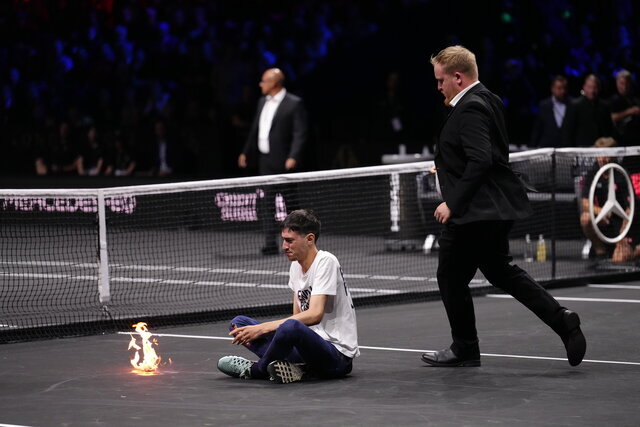 عکس | جنجال عجیب وسط مسابقات تنیس | یک هوادار خود را آتش زد! | پیام معنادار روی تی‌شرت فرد معترض