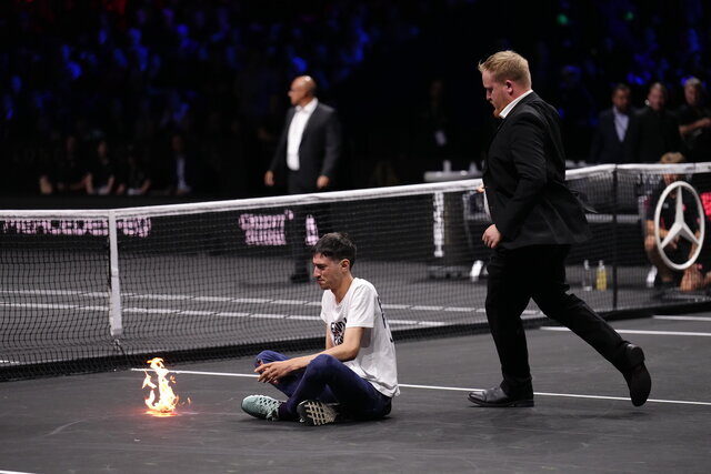 عکس | جنجال عجیب وسط مسابقات تنیس | یک هوادار خود را آتش زد! | پیام معنادار روی تیشرت فرد معترض