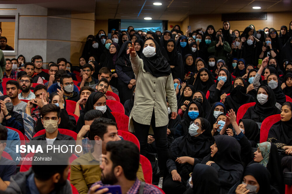 تصاویر | دختری که از کف سالن به بالای سن سخنرانی سخنگوی دولت پرید | دختر معترض هم جای مجری را گرفت