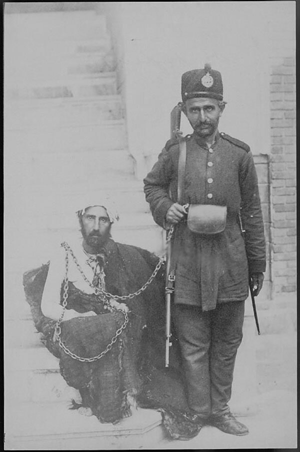عکس مشهوری از قاتل ناصر الدین شاه | در زمان قاجار دزدان اینگونه زندانی می‌شدند