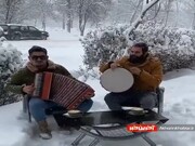 ببینید | صحنه‌هایی زیبا از نواختن موسیقی محلی هنگام بارش برف