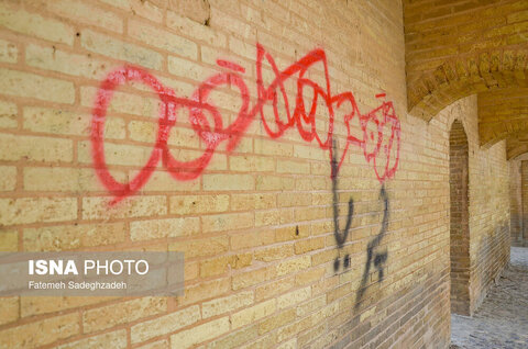 شعار نویسی زشت روی دیوارهای پل سی و سه پل