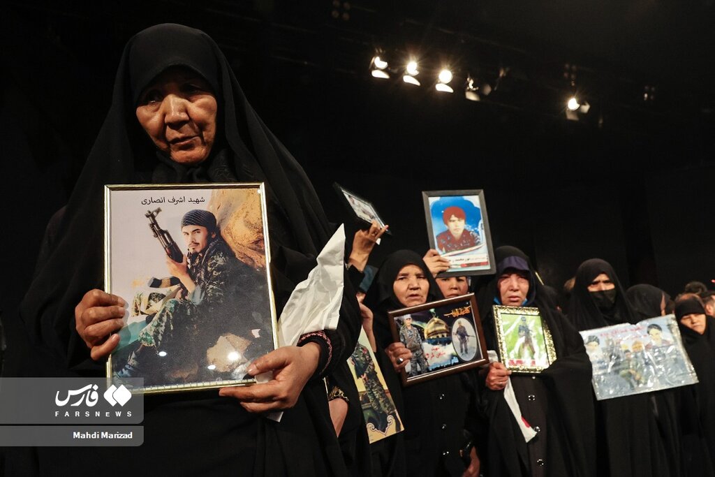 عکس یادگاری محسن رضایی با خانواده شهدای مدافع حرم فاطمیون