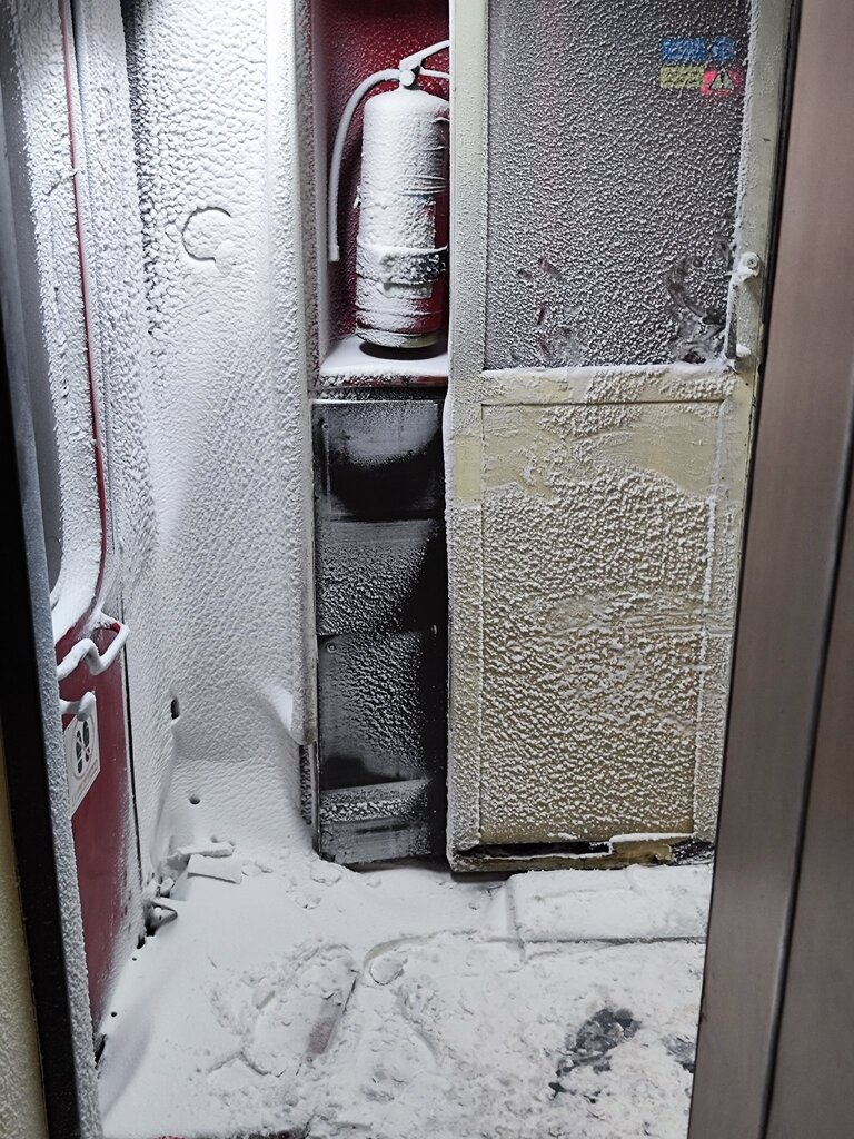 تصویری از در ورودی یکی از واگن‌های قطار یخ زده در مسیر مشهد