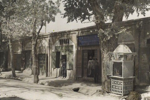  تهران؛ سقاخانه‌ای در کنار یکی از خیابان‌ها؛ یک مغازۀ کفاشی هم در تصویر مشخص است