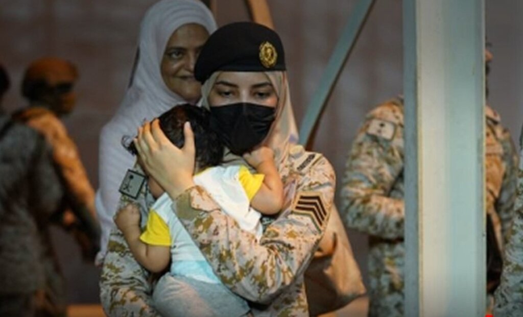 سرباز زن سعودی باکودکی در آغوش