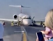 تصاویر لحظه دلهره آور فرود هواپیما با چرخ شکسته | پایین آمدن مسافران از سرسره اضطراری را ببینید