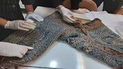تصاویر لحظه مرمت لباس جهان پهلوان تختی توسط مرمت‌گران آثار تاریخی