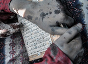 تصاویر زن فلسطینی بیرون آمده از زیر آوار با قرآن در دست