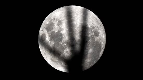 تصویر میله برق‌گیر یک فانوس دریایی روی ماه کامل بر فراز ساحل کیاما سرف سیدنی
