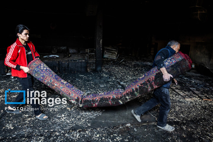 نمازگزاران درحال جمع آوری فرش های سوخته مسجد هستند.