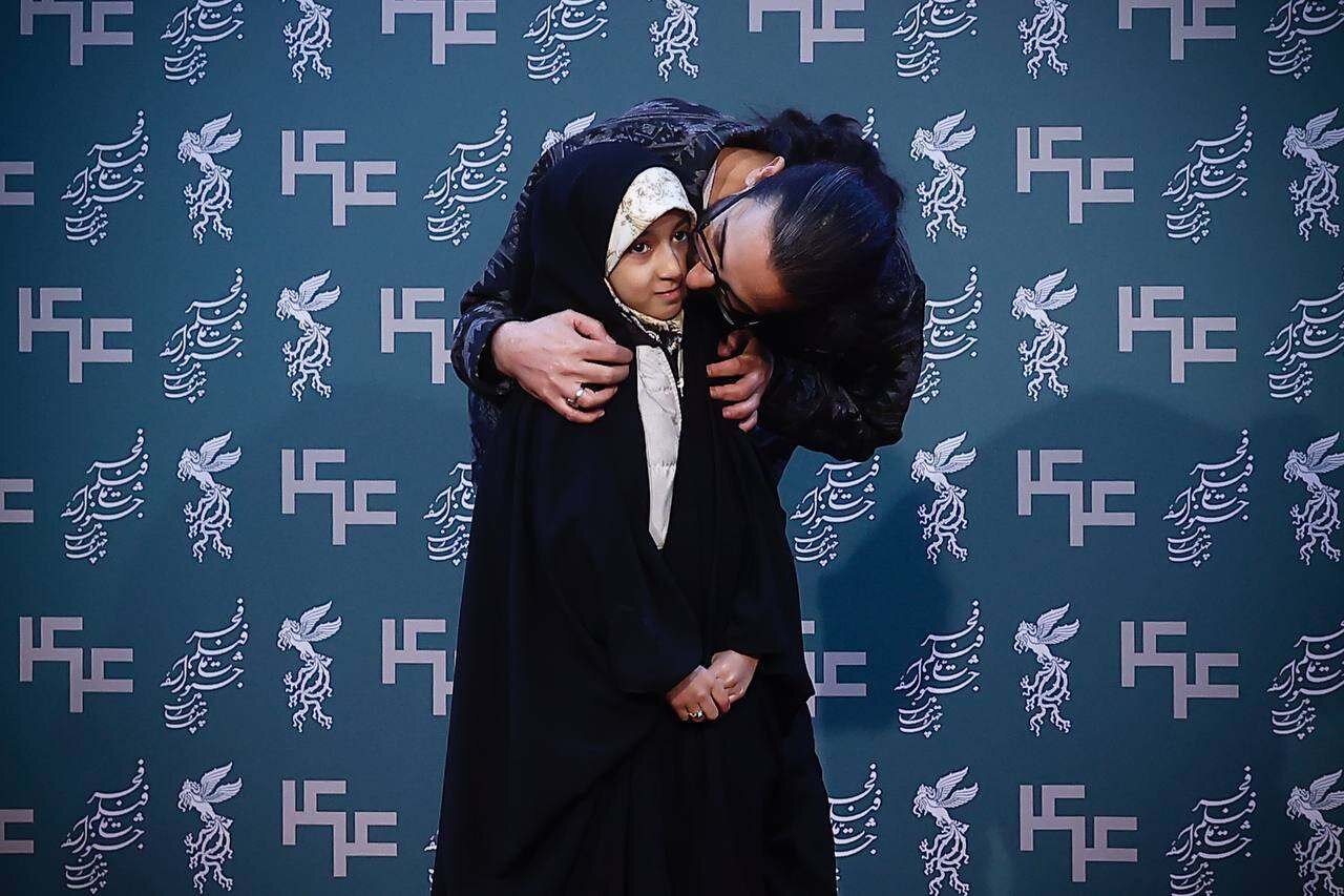 بوسه کارگردان «حاشیه» بر صورت دختر چادریاش روی فرش قرمز | تصاویر