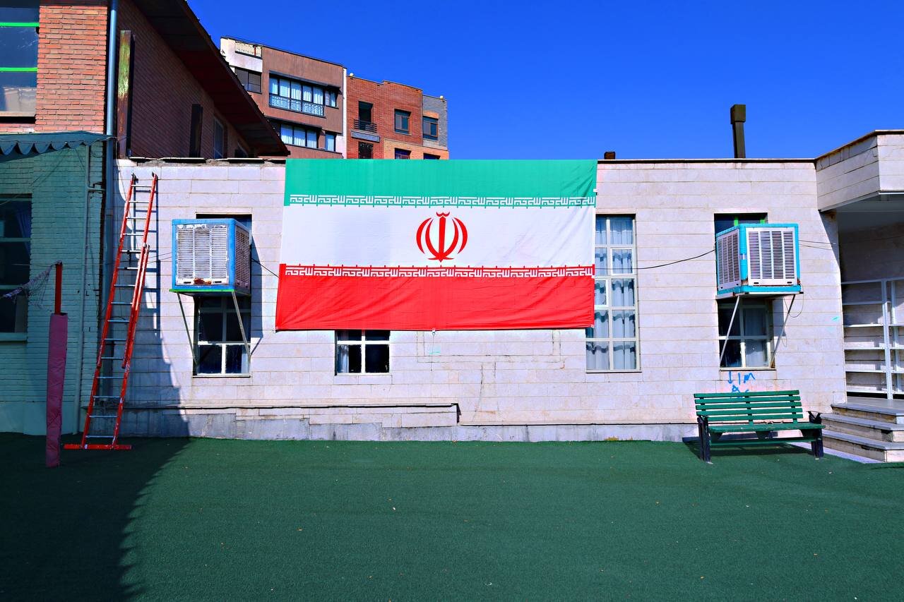 نصب پرچم بر سردر ۵۷ مدرسه شهیدپرور تهران